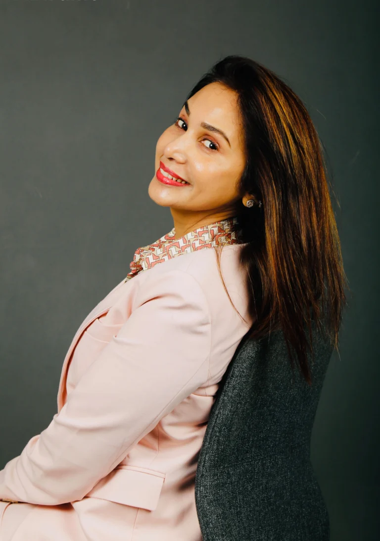 Actress Preeti Mallapurkar sitting with a smile in a formal suit