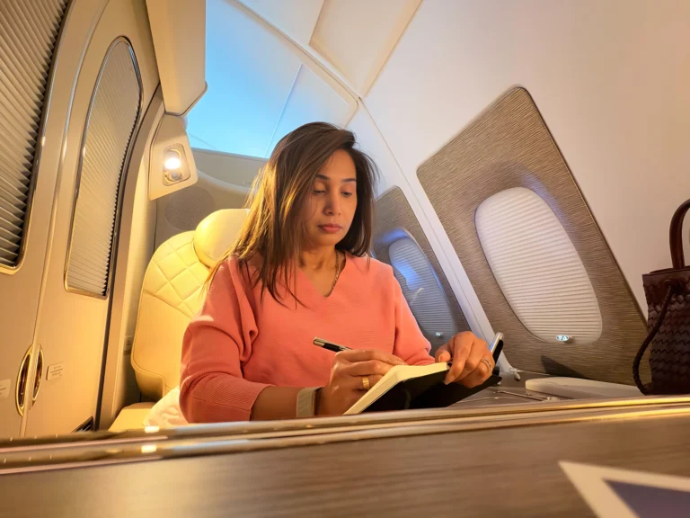 Famous Indian marathi Actress who is also a famous book writer, sitting with her notebook writing down her ideas even while she is travelling by airplane, making her travel journey also productive.